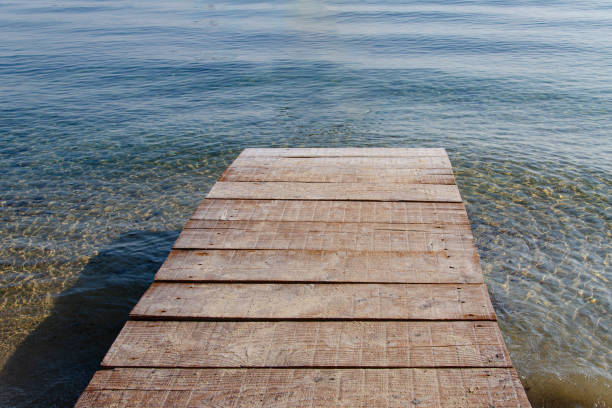 ponte de pesca de madeira e água ao seu redor - plank boardwalk pontoon bridge summer - fotografias e filmes do acervo