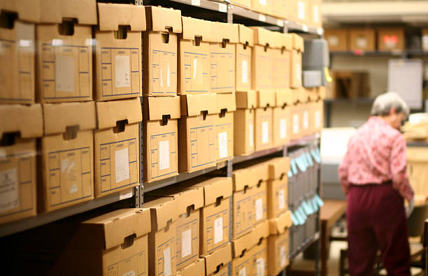 Record Room An elderly lady stands near the back of a record room at a library. document storage stock pictures, royalty-free photos & images