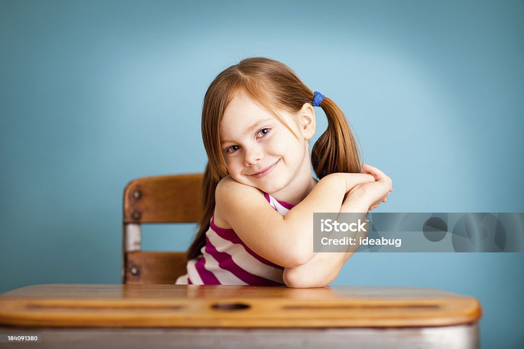 Giovane studente felice, timido scuola ragazza seduto alla scrivania - Foto stock royalty-free di 4-5 anni