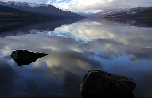 A winter morning at Loch Arkaig in Scotland. The water is so still it acts like a giant mirror.