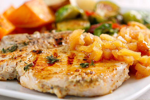 istock Garlic-herbed pork chops served with applesauce 184092147