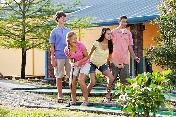 istock Teenage couples playing miniature golf 184092365