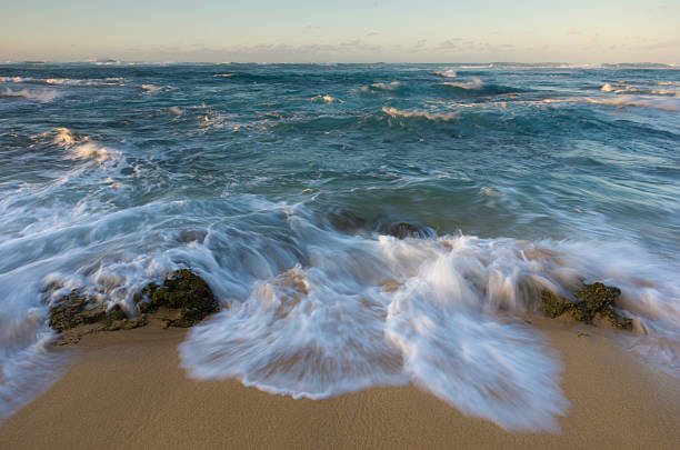 istock Rough seas and waves crash over beach rocks 184092400