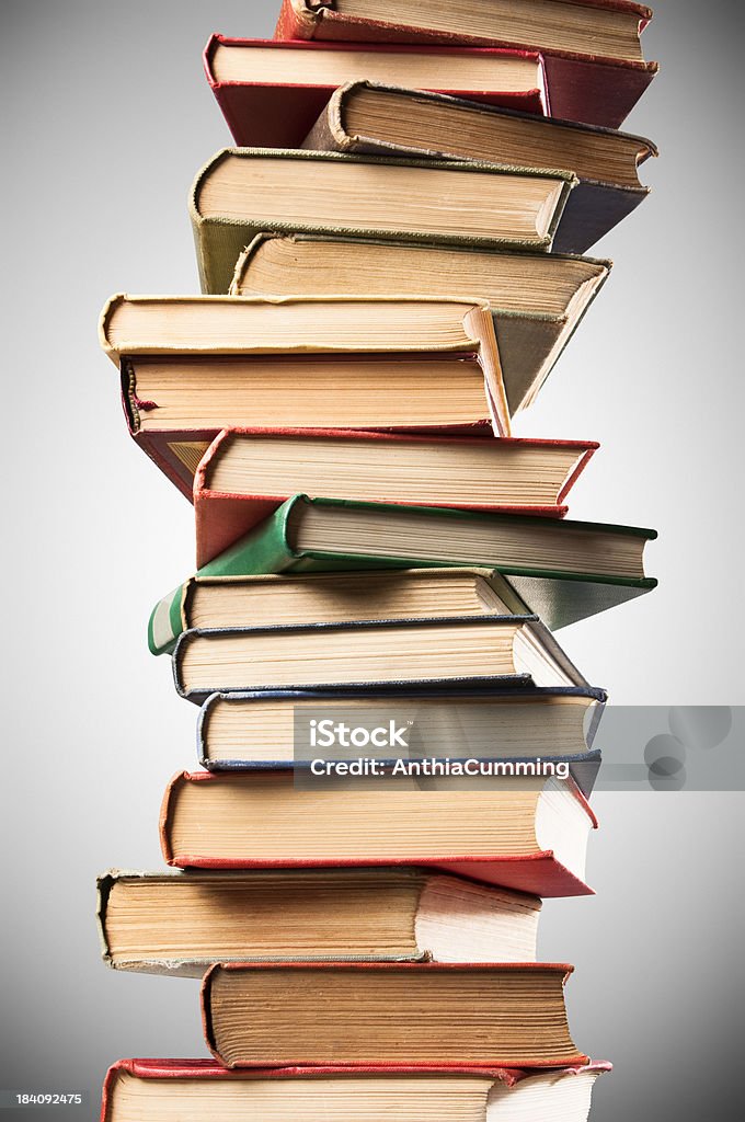 Wobbly pilhas de couro velho com destino de livros sobre Fundo cinza - Foto de stock de Amontoamento royalty-free