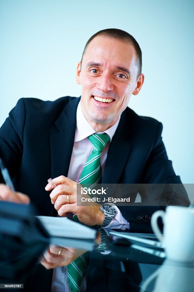Elegante hombre de negocios sonriendo mientras escribir notas en oficina - Foto de stock de Adulto libre de derechos