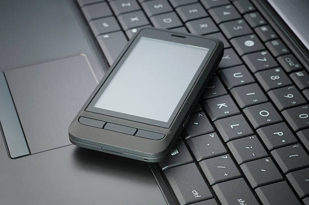 istock cell phone on the laptop 184094623