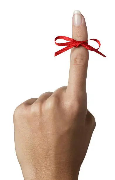 Photo of Woman holding up index finger tied with red bow