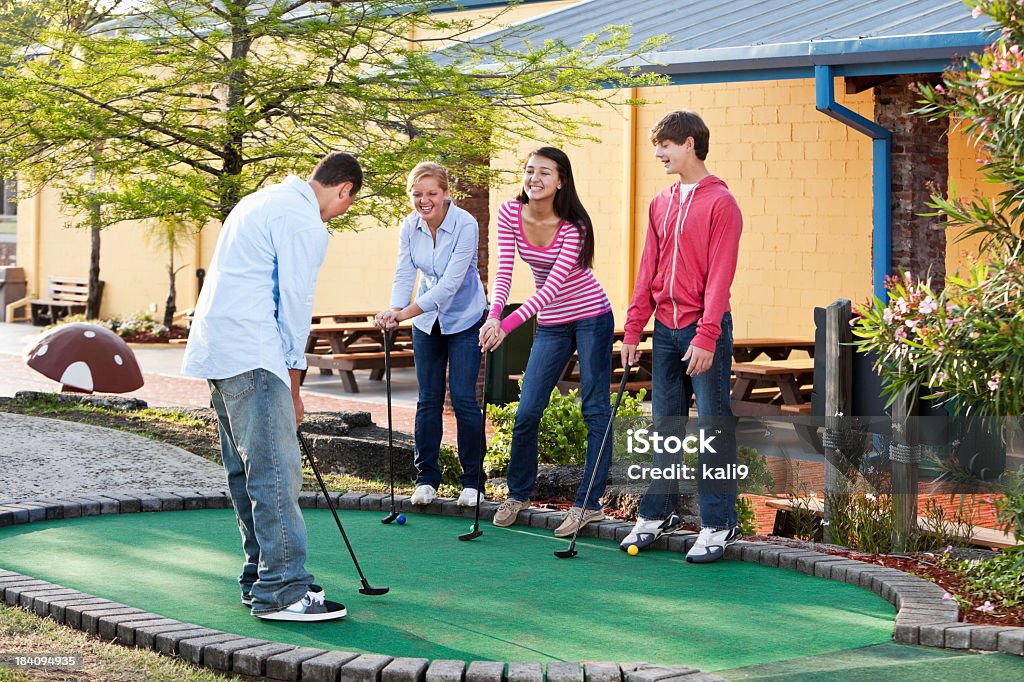 Adolescentes jogando golfe em miniatura - Foto de stock de Golfinho - Atividade royalty-free