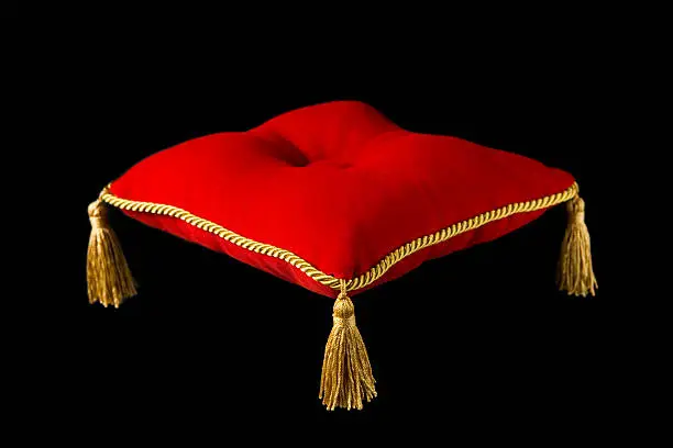 A red velvet tufted presentation pillow