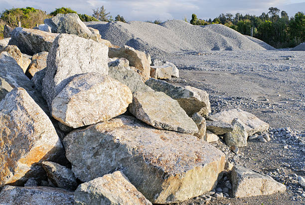 A heap of large rugged stone blocks with gravel piles in the background.