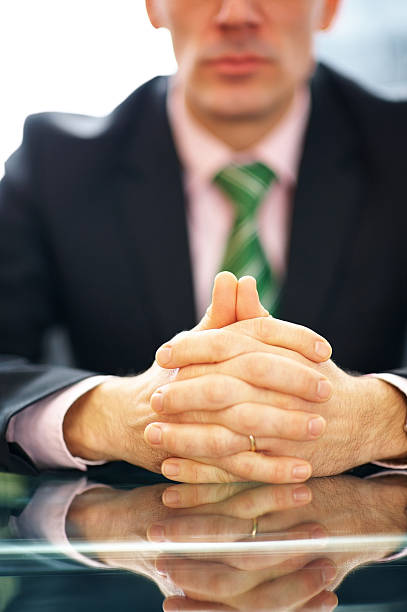 istock Closeup of business man sitting with hands folded 184095676