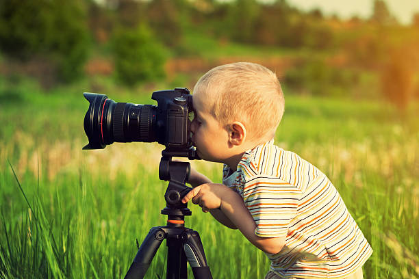 istock A little boy looking into a camera on a tripod 184095733