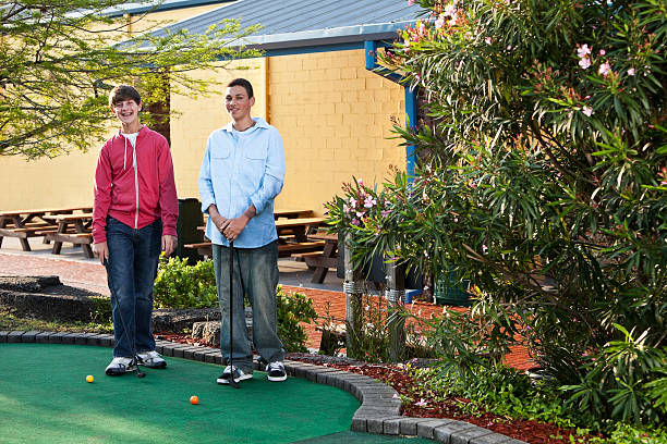 istock Teenage boys playing miniature golf 184096814