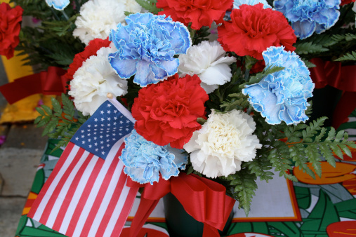 Subject, A display of red, white and blue flowers with the flag of United States of America in a holiday celebration