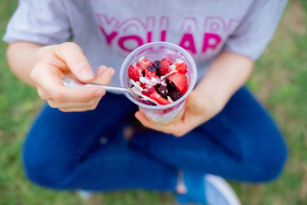 istock Woman with plastic container eating yogurt with cereals 1840968903