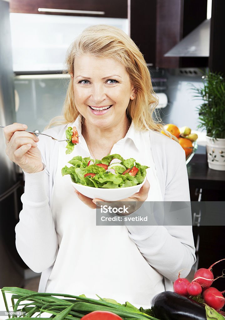 Bella donna matura mangiare insalata. - Foto stock royalty-free di Cucina vegetariana