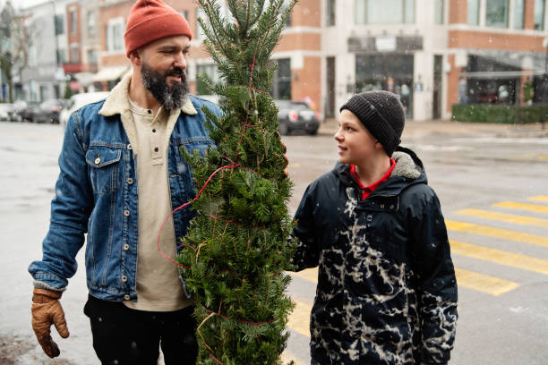 istock Urban father and son bringing home a Christmas tree. 1840969426