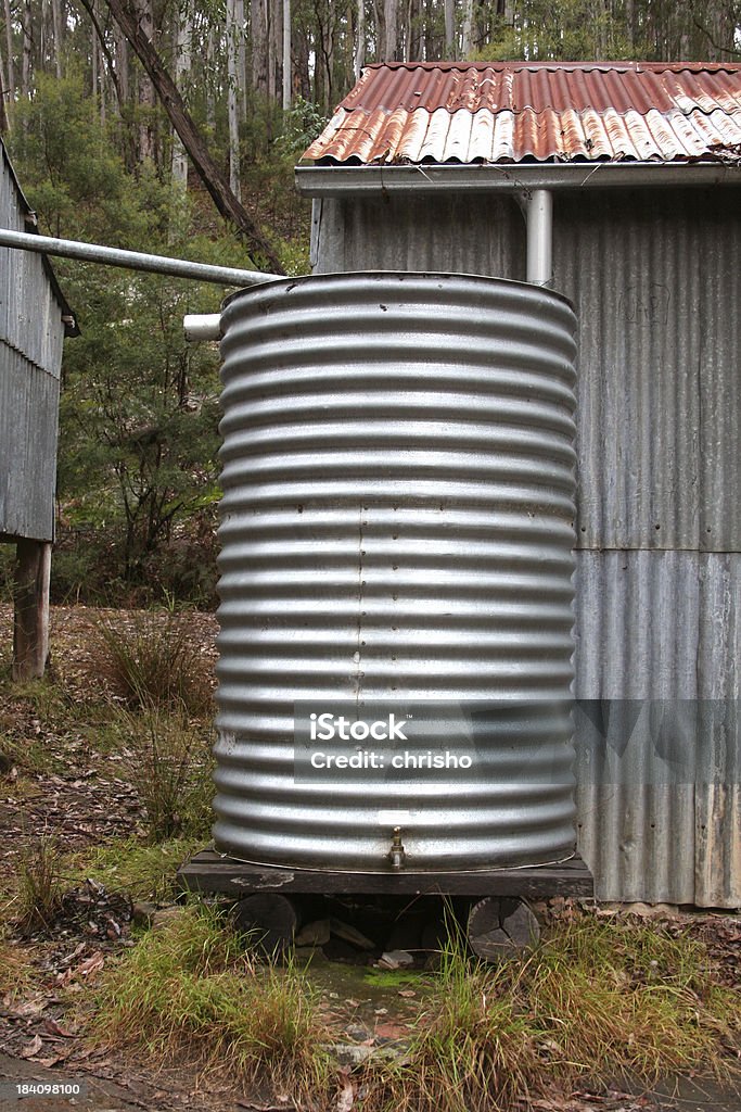 Rain water collection tank A rain water collection tank made of corrugated iron with a tap. Bush Stock Photo