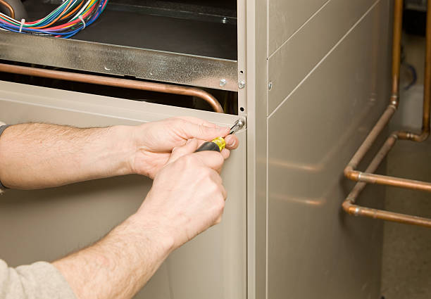 Repair Technician Removing Furnace Service Panel  furnace photos stock pictures, royalty-free photos & images