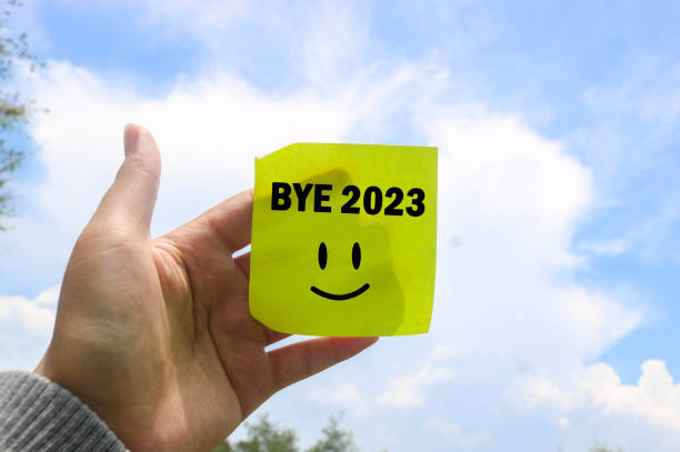 istock Hand holding a note writing Bye 2023 with a blue sky and clouds background. new life and new year 2024 concept. say goodbye to 2023 1840991505