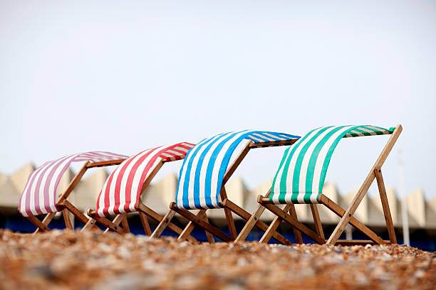 Empty deckchairs Four deck chairs on Brighton beach. brighton england stock pictures, royalty-free photos & images