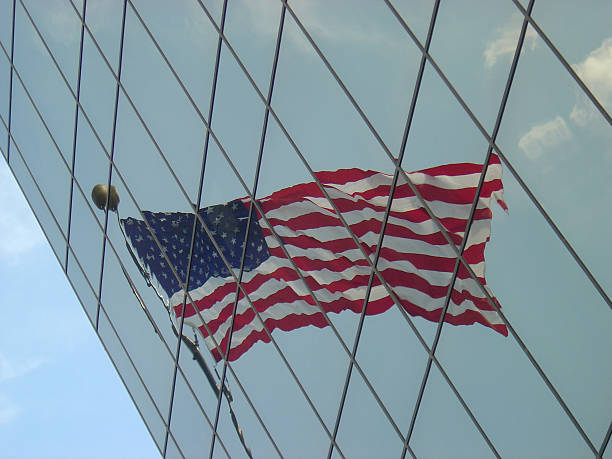 флаг отражающий в остроугольный офисное здание - government flag american culture technology стоковые фото и изображения