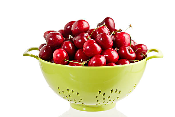 cerises dans un green colander - colander photos et images de collection