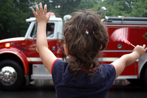 istock Little Girl Waves at Patriotic Parade 184100235