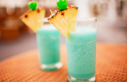 Two tropical cocktails made with rum, curaçao and pineapple juice.