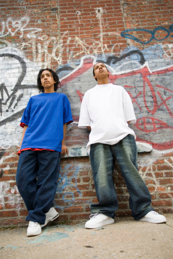 Two Hispanic boys at the brick wall. Perspective shot.