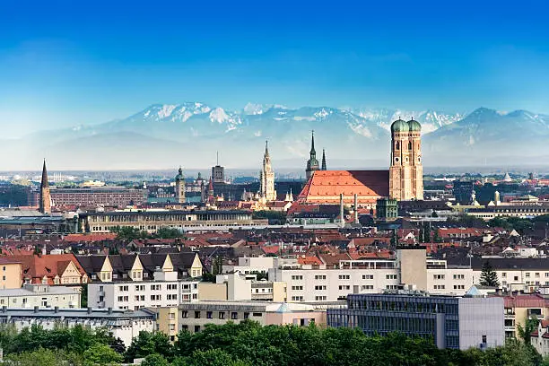 Munich, capital city of Germany's Free State of Bavaria. CIty skyline in the evening light. The Alps visible in the background.