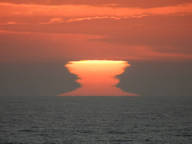 Bondi Beach Sunrise Light The sun appears over the horizon over the Pacific Ocean, causing this effect as it interacts with the atmosphere and clouds. This image was taken at sunrise on 9 December 2023. bondi beach sunrise stock pictures, royalty-free photos & images