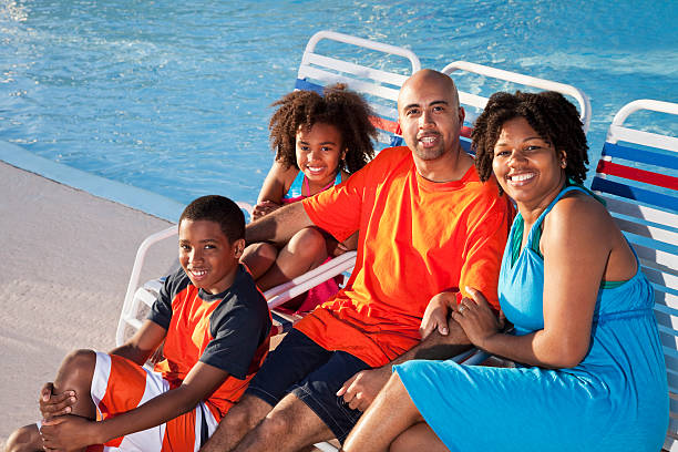 afro-américaine famille sur les chaises longues au bord de la piscine - sc0484 photos et images de collection