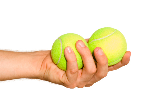 hand holds tennis balls