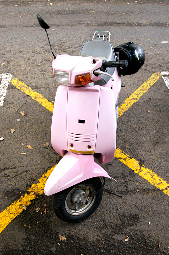 Cute pink motor scooter parked on a yellow no parking cross (makes a great (different) 'site under construction' notice