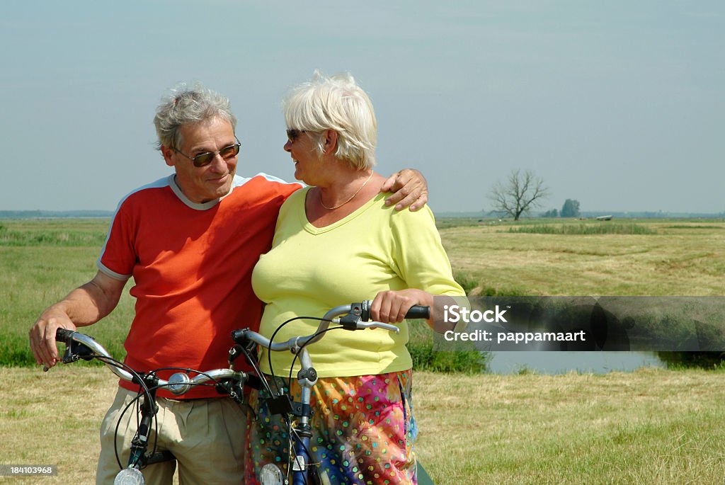 Felice Amorevole Coppia Senior con la loro biciclette in olandese polder - Foto stock royalty-free di 60-69 anni