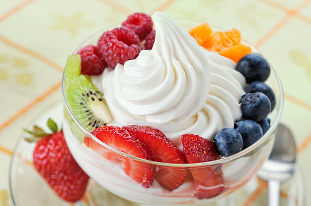 Frozen Yogurt with Fresh Fruit SEVERAL MORE IN THIS SERIES. DIsh of vanilla soft-serve frozen yogurt surrounded by a variety of fresh fruits.  Shallow DOF. frozen yoghurt stock pictures, royalty-free photos & images