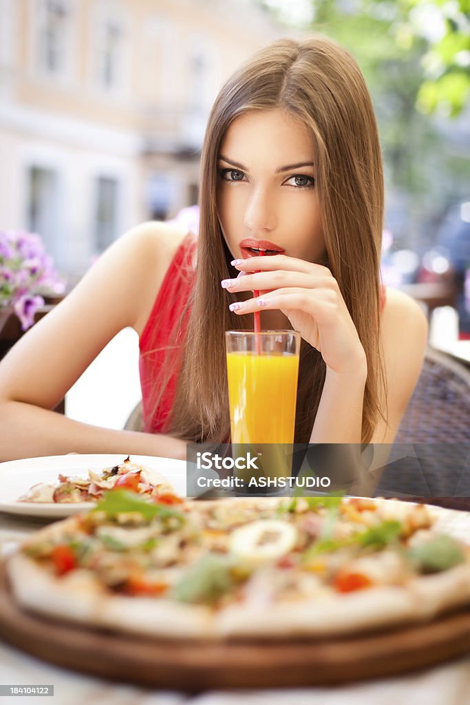 Молодая женщина пьет сок в «cafe - Стоковые фото Девушки роялти-фри
