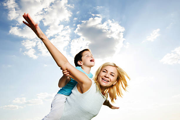 istock Beautiful mother giving her son a piggyback ride. 184105220