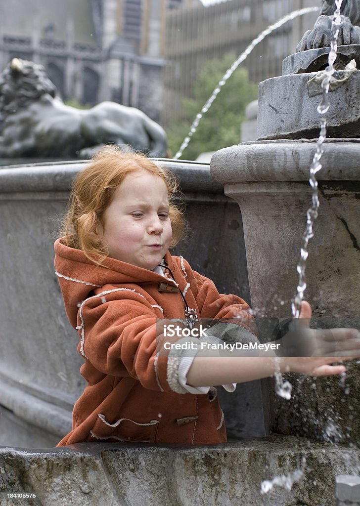 girl having fun with a fountain "Little girl, aged 5, holding her hand in the water of a street fountain.Location: Liege, Belgium." Activity Stock Photo