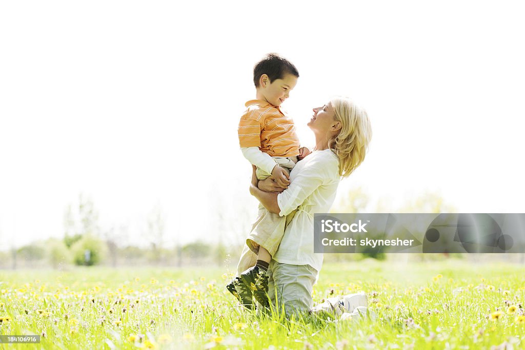 Madre se sostiene a su hijo en el parque. - Foto de stock de Actividad libre de derechos