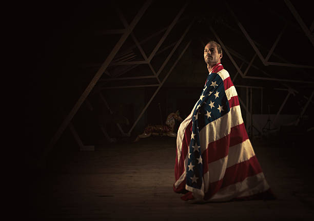 istock man seating with a huge flag covering him 184107087