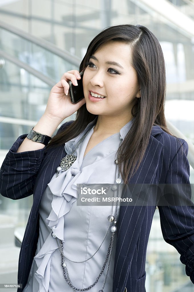Business Portrait A smiling business portrait of an Asian woman talking on a phone. 20-29 Years Stock Photo