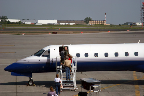 A soldier turns and waves as he boards a small plane. (colors changed and logos removed from plane)