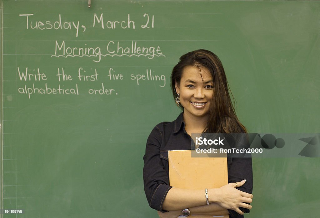 Teacher Grade school teacher in front of chalkboard. Elementary School Stock Photo