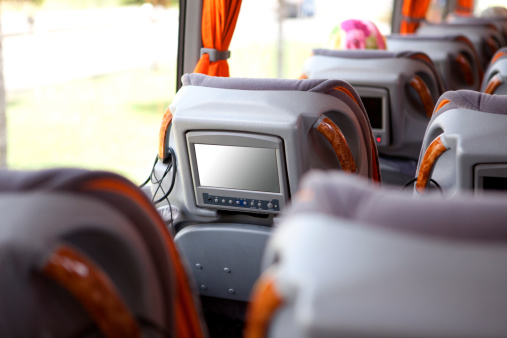 Modern luxury bus travel interior.Television in armchair.