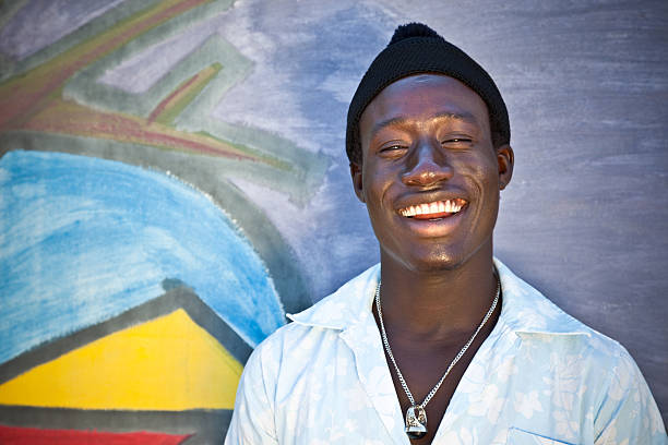 Portrait of an happy African man in front of a wall with graffiti.