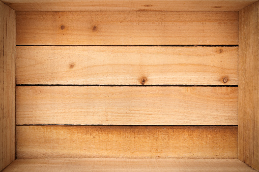 The inside of an empty wooden crate.