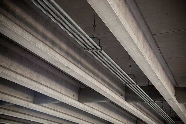 Low angle view of highway overpass with beams and conduit stock photo
