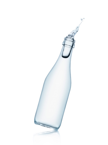 Bottle tilted with splashing water isolated on white backgroundSEE OTHER SIMILAR PICTURES
